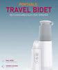 Portable travel bidet with rechargeable electric sprayer on a light blue background